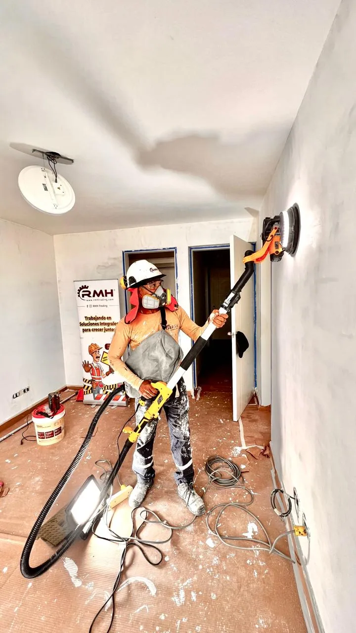 Trabajador de RMH utilizando una lijadora profesional para acabados de muros