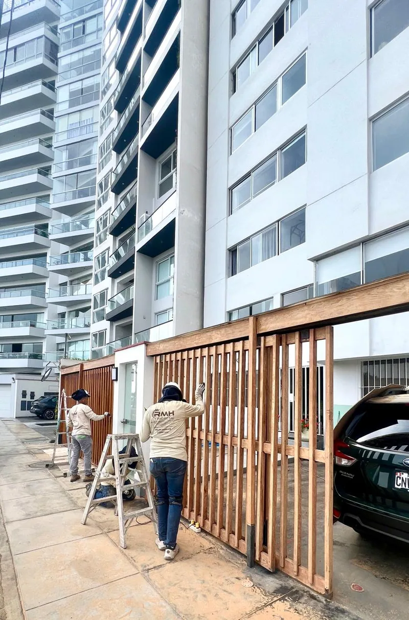 Personal de RMH Trading trabajando sobre un portón de madera en un edificio